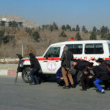 در عکس چند عکاس و خبرنگار افغانستانی نشان داده می‌شود که پشت آمبولانسی پناه گرفته‌اند.