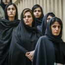 شش زن با حجاب اجباری روی پله‌های یک پلکان رو به دوربین ایستاده‌اند.